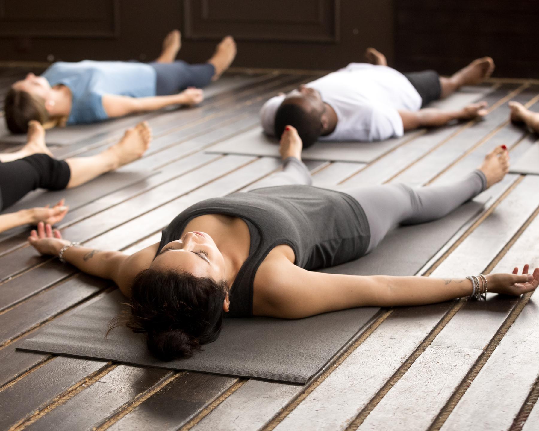 A group resting on mats in a warm wood-panelled room after a breathwork session
